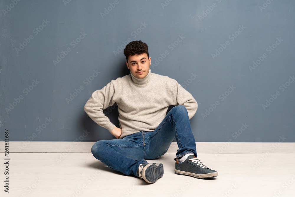 Young man sitting on the floor angry Young man sitting on the floor angry