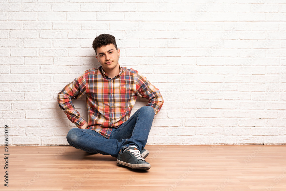 Young man sitting on the floor angry Young man sitting on the floor angry