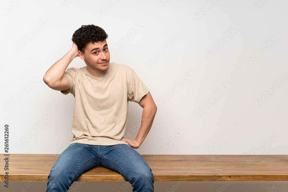 Young man sitting on table thinking an idea Young man sitting on table thinking an idea
