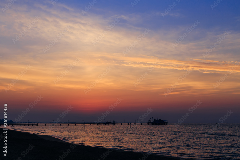 the sky after sunset. ripple on the sea water, pier and silhouet