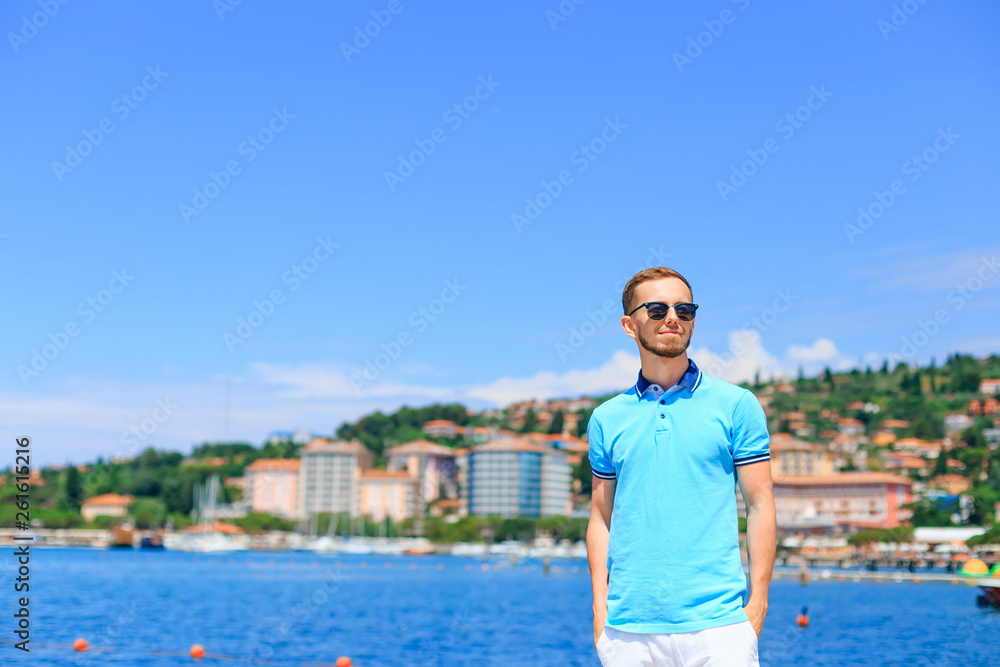 stylish young bearded man in a polo smile on the background of t