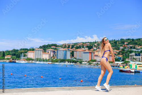  sexy woman has blue swimsuit, sunglasses have fun on a beach. c