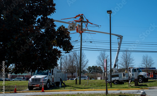 men in bucket on extended cherry pickers
