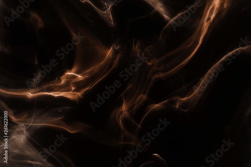 Orange foggy paper texture on the black background, smoky effect for photos and artworks. Chaotic abstract background.