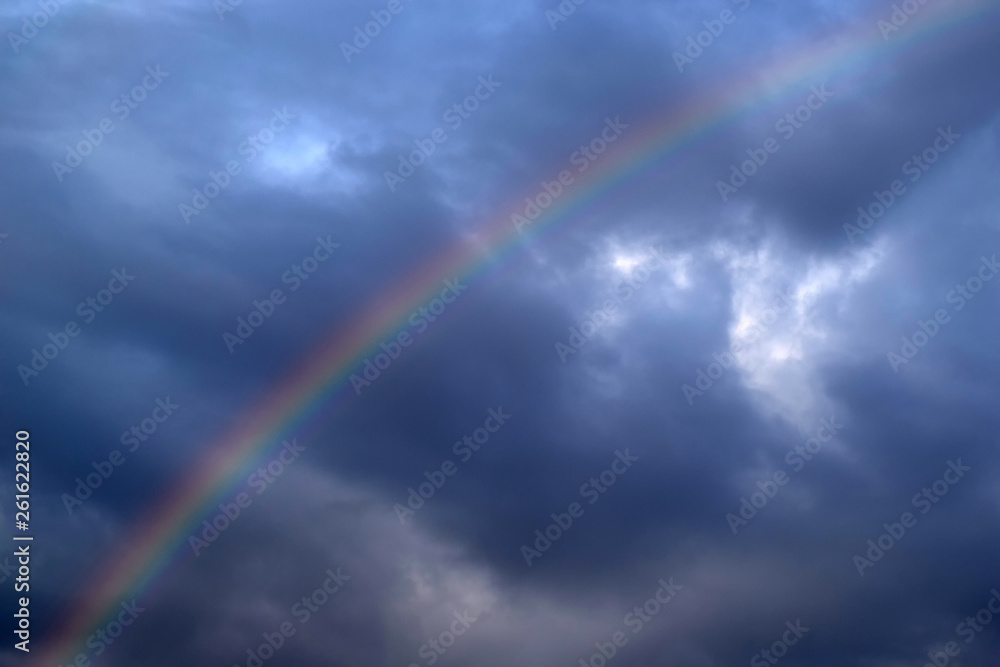 Beautiful rainbow with clouds and rain . Spring warmth Beautiful rainbow with clouds and rain . Spring warmth