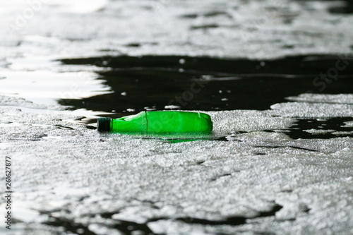 green plastic bottle floating in ocean
