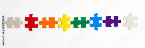 equality concept: LGBT pride flag built from a puzzle, among gray puzzles short focus, top view