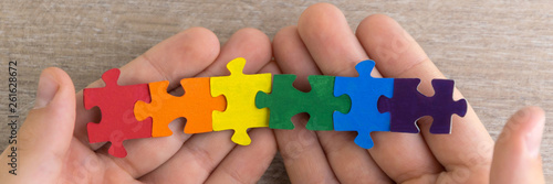 teaching sexual tolerance in school and at home: a boy builds an LGBT flag using puzzles