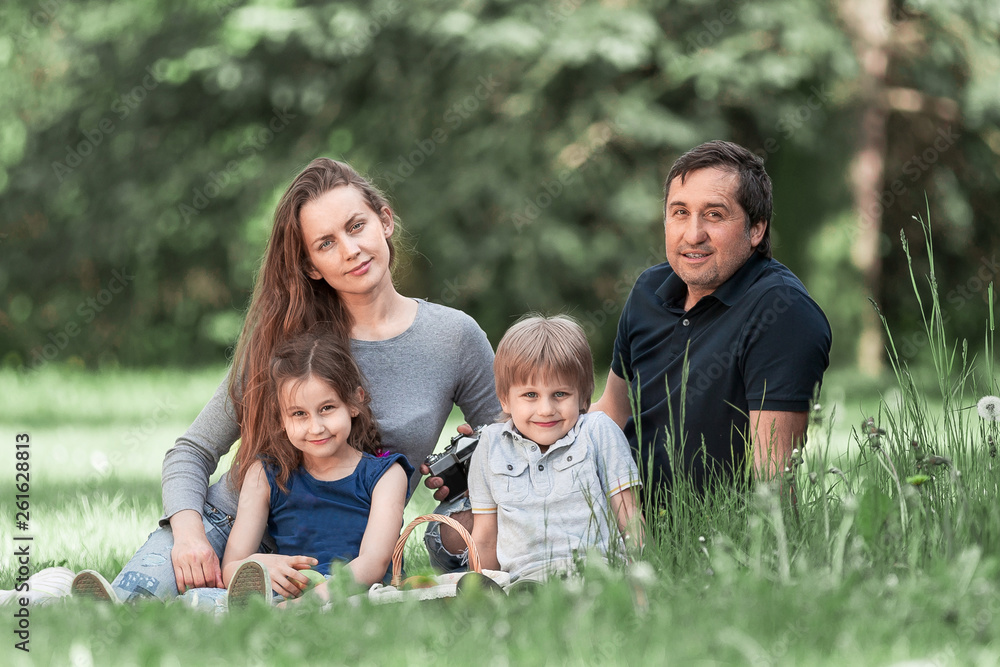 parents with small two children on the lawn on a spring day parents with small two children on the lawn on a spring day