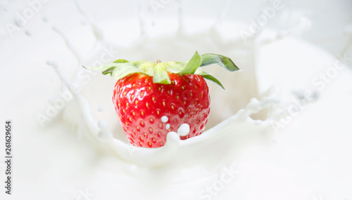 1 strawberry drops into milk