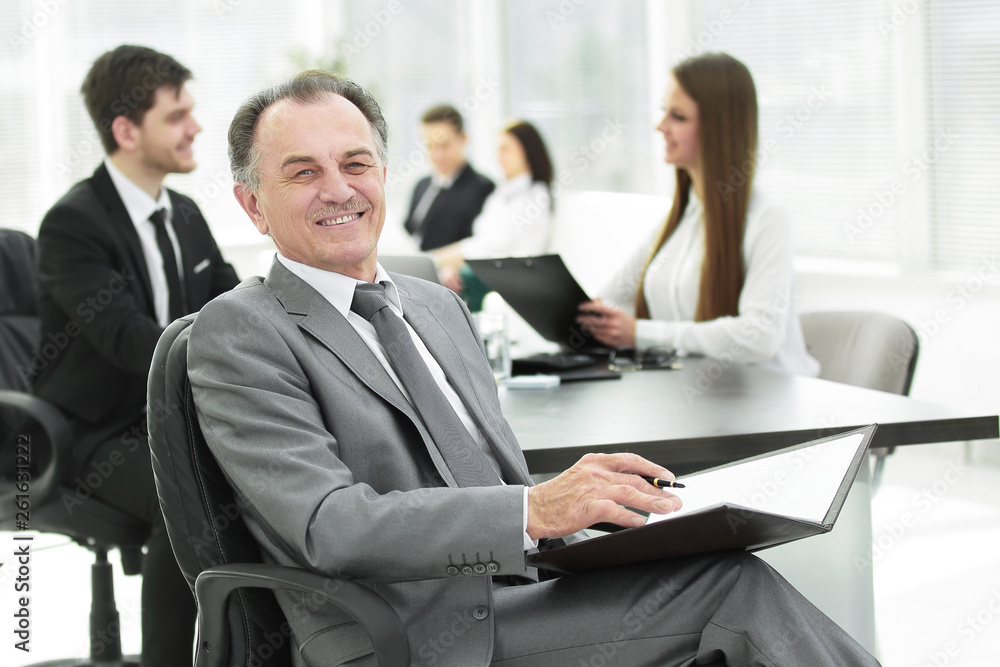 senior businessman with a clipboard on the background of the office senior businessman with a clipboard on the background of the office