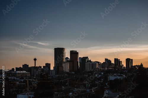 Calgary skyline in the late afternoon with rays from setting sun reflecting off glass buildings.