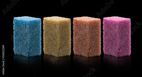 Sugar lumps piled up together against a black background