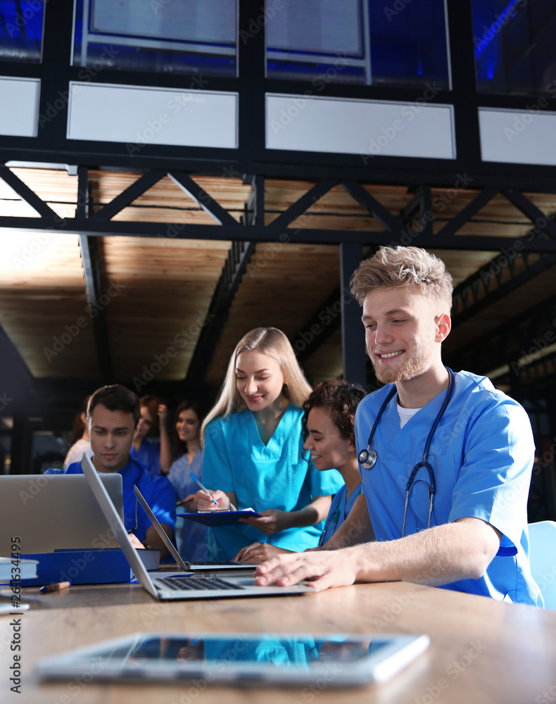 Group of smart medical students with gadgets in college Group of smart medical students with gadgets in college