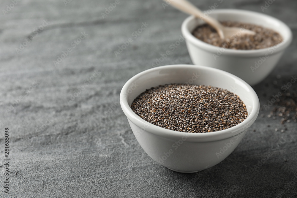 Bowl with chia seeds on grey background, space for text Bowl with chia seeds on grey background, space for text