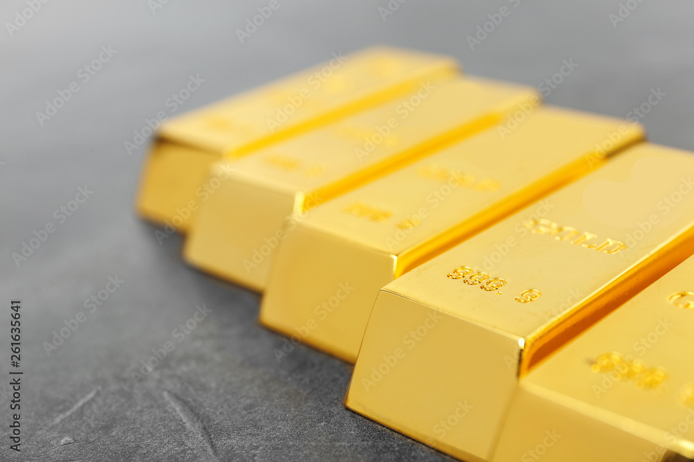 Shiny gold bars on grey background, closeup Shiny gold bars on grey background, closeup