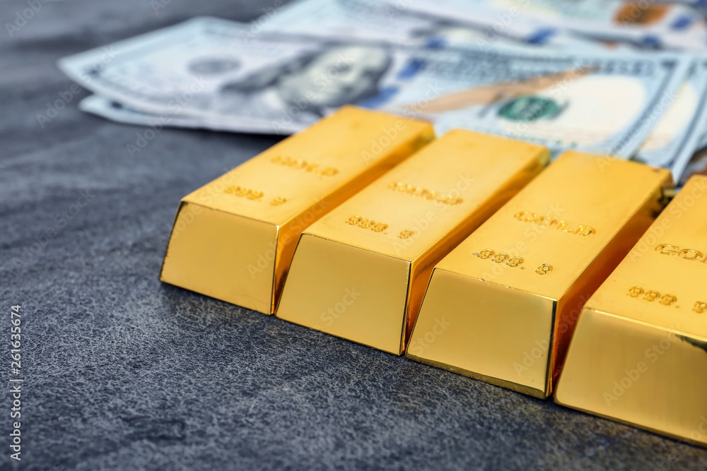 Gold bars and dollar bills on table, closeup Gold bars and dollar bills on table, closeup