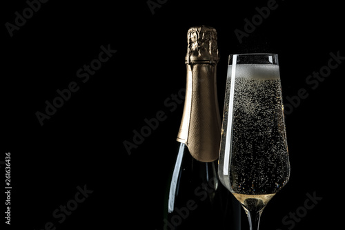 Fotografie, Tablou Bottle and glass of champagne on black background, space for text