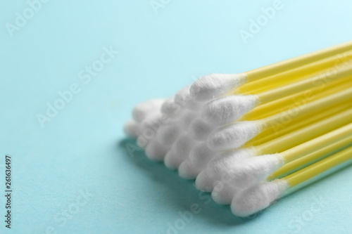 Pile of cotton swabs on color background  closeup. Space for text
