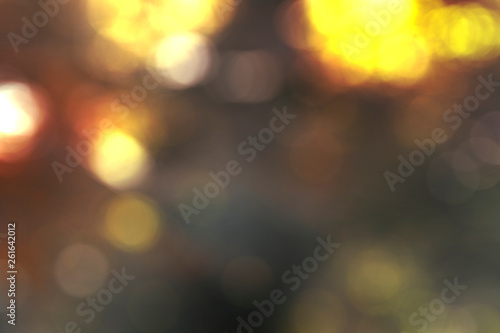 Abstract blurred bokeh background, glowing gold, soft brown, red, and earth tones. Lights out of focus festive warm cozy atmosphere blurry wallpaper. 