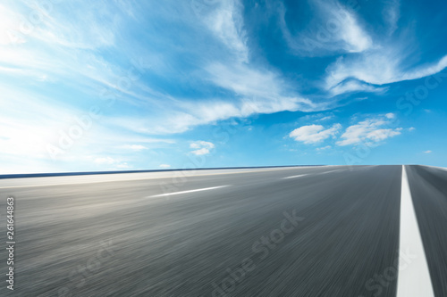 Motion blurred asphalt road ground and sky clouds scene