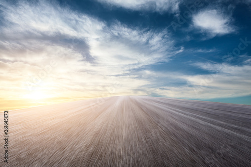 Motion blurred asphalt road ground and sky sunset clouds