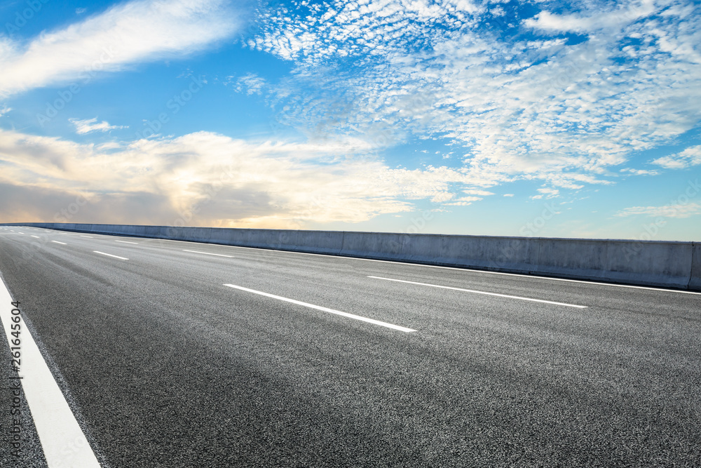 Fototapeta premium Empty asphalt road ground and blue sky with white clouds scene