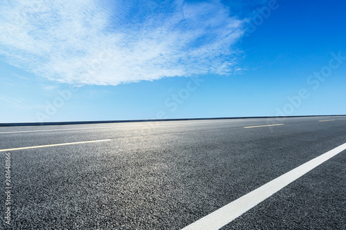 Empty asphalt road ground and blue sky with white clouds scene © ABCDstock