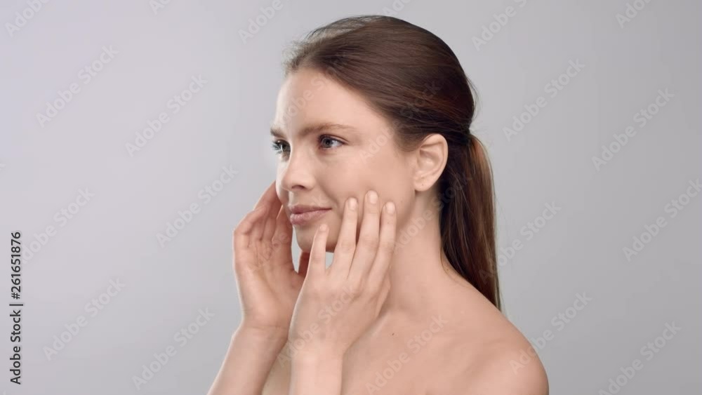 Young woman turning to the camera touching her face and smile Young woman turning to the camera touching her face and smile