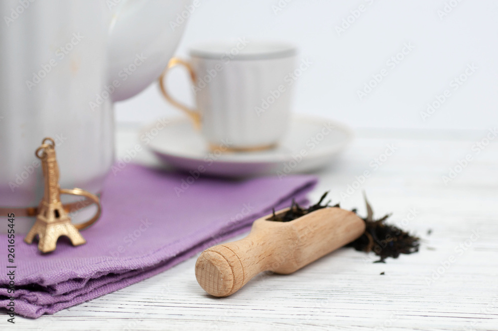 Teapot and cups on the wooden white table. Aromatic black tea. Concept of tea ceremony, break and having rest.