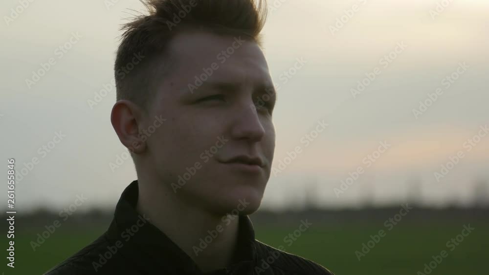 silhouette portrait of handsome young man on the nature background at sunset