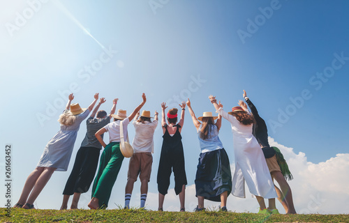 Group of happy joyful young stylish people against blue sky, friendship, community values, joint travel photo