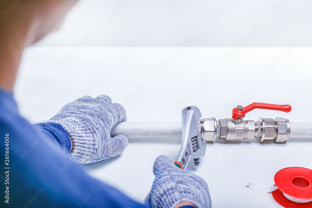 Male Plumber's Hand Repairing Sink Pipe Leakage With Adjustable Wrench. Plumbing service concept. Copy space. Male Plumber's Hand Repairing Sink Pipe Leakage With Adjustable Wrench. Plumbing service concept. Copy space.