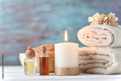 Towels  candle and massage oil on white table
