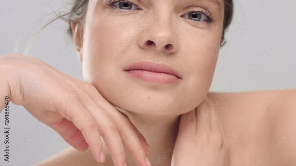 Woman touching her face with her hands and looking at camera Woman touching her face with her hands and looking at camera
