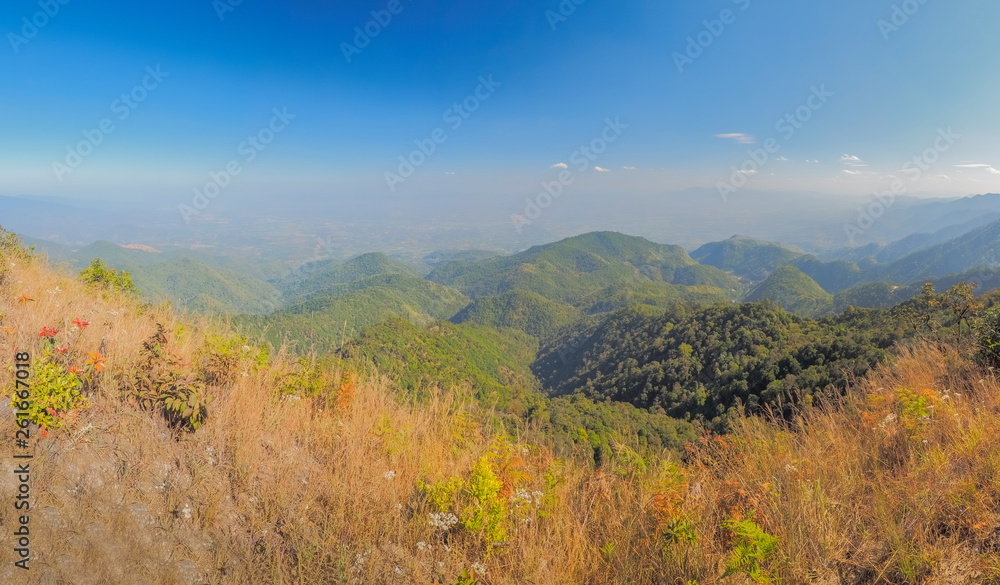 Mountain view morning on top of Doi Ang Khang above many hills and green forest cover with soft mist and blue sky background, Doi Angkhang, Chiang Mai, northern of Thailand.