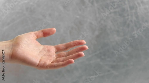Outstretched woman's palm on grey background. Hand close-up. Side view. photo