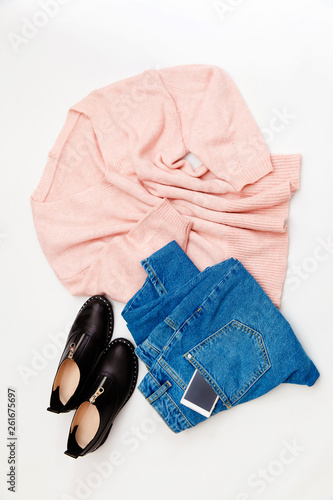 Women's fashion clothing and accessories. Female youth collage on white background top view. A flat lay-out in feminine style looks with a warm sweater, jeans, shoes. Top view. 