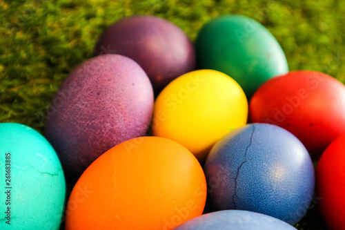 several colorful easter eggs on the green grass background closeup