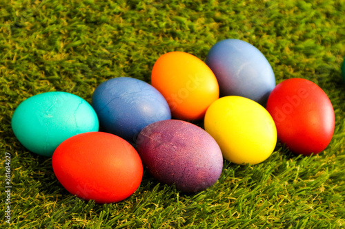 bunch of colorful bright easter eggs in the green grass