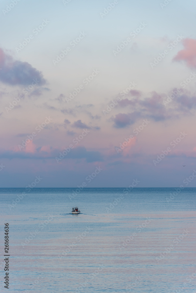 Mirror Still Mediterranean Sea on the Southern Italian Coast at Sunrise with Tiny Fishing Boat