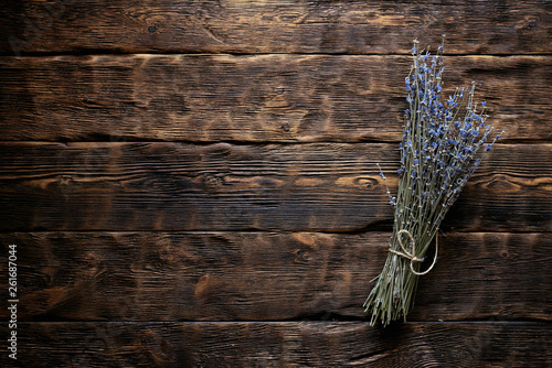 Dried lavender flower branch on a wooden table background with copy space. Herbal medicine concept.