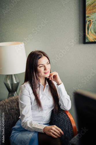 Time for morning latest news Profile side view photo of brown-haired lady sitting in a comfortable arm chair in a formal white blouse reading fresh newspaper.