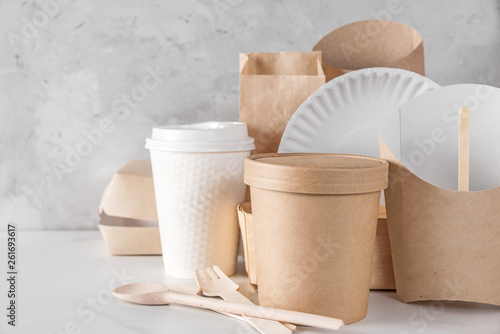 eco friendly disposable dishes made of bamboo wood and paper on white marble background. recycling concept