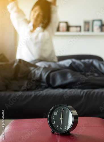 Blured woman stretch lazily in bedroom after waking up in the morning photo