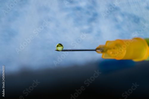 macro view of a hypodemic needle with a drop of drug solution on his peak photo