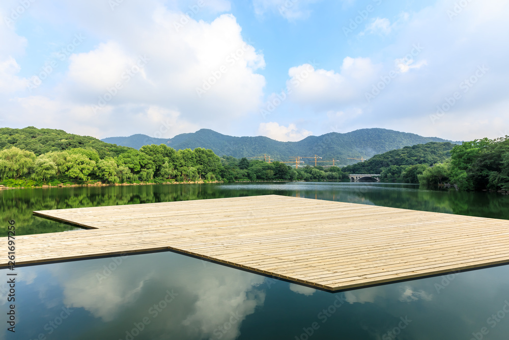 Obraz premium Wooden floor platform and lake with green mountains background in Hangzhou