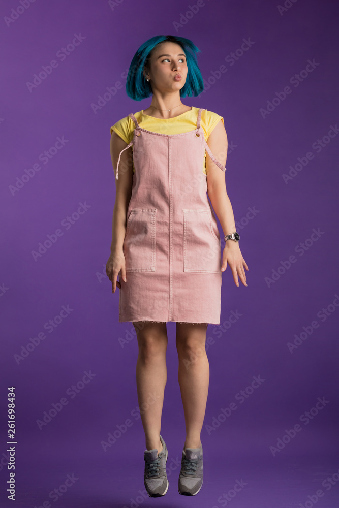 funny stylish girl jumping with pensive expression. full length photo. hipster humming while jumping in the studio. funny stylish girl jumping with pensive expression. full length photo. hipster humming while jumping in the studio.