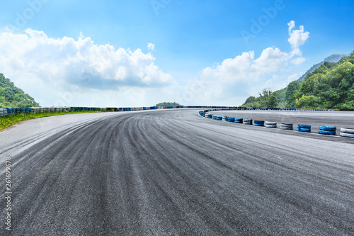 Tableau sur toile Asphalt race track ground and mountains with blue sky landscape