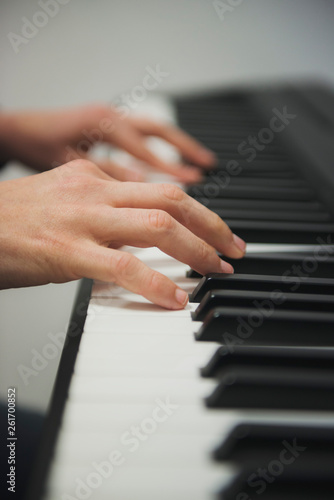 hands of a woman playing piano
